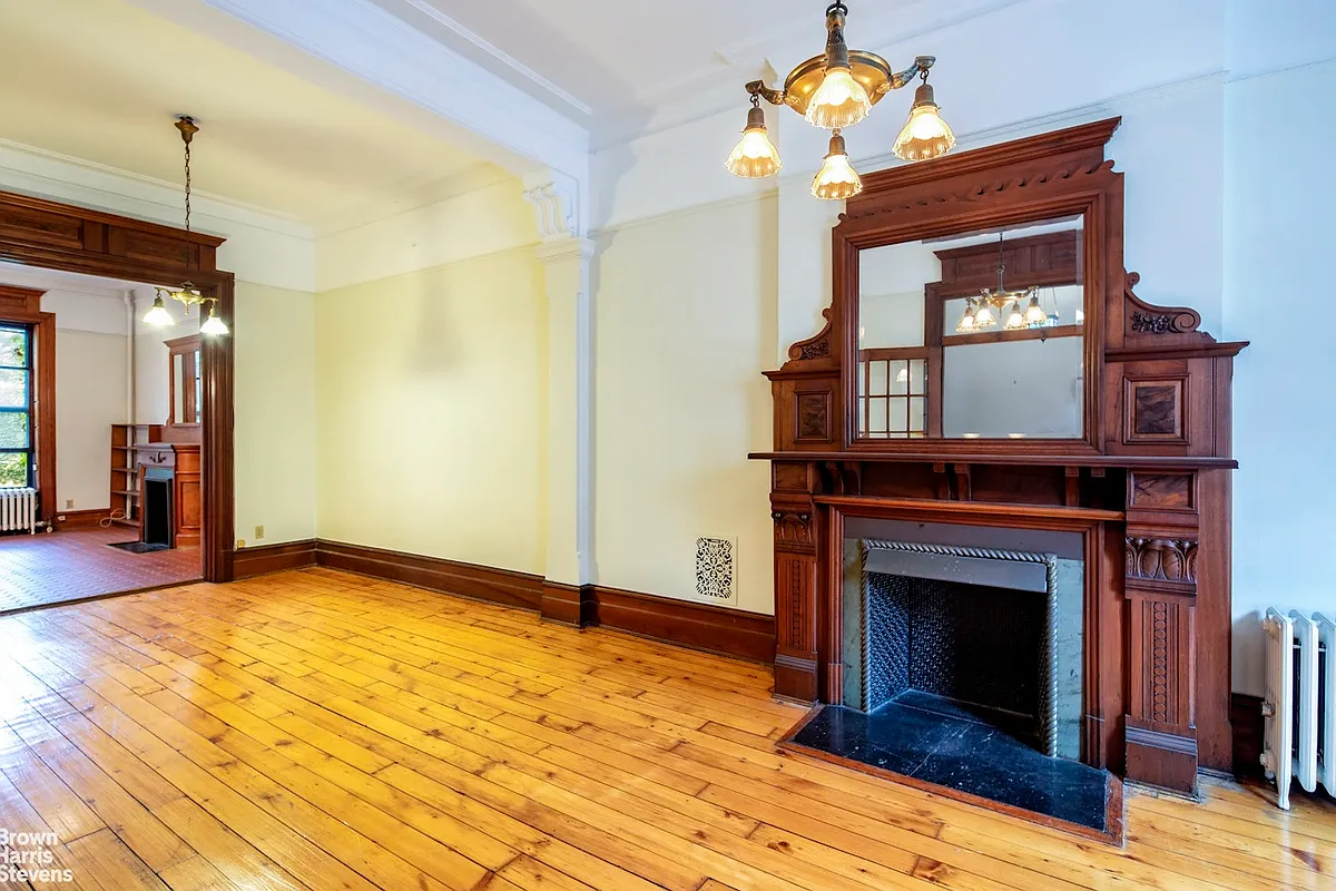 parlor with wood floor, mantel with mirror above