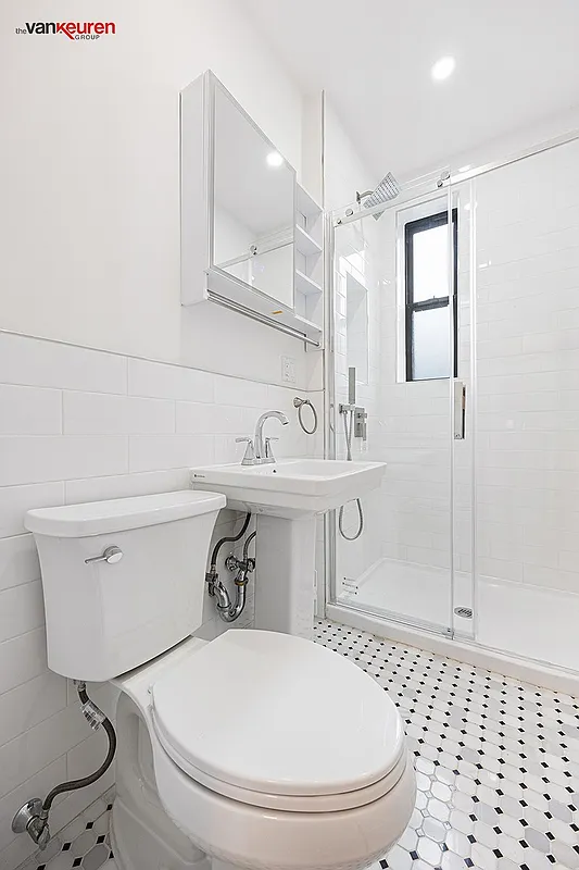 bathroom with a walk-in shower and black and white floor tile