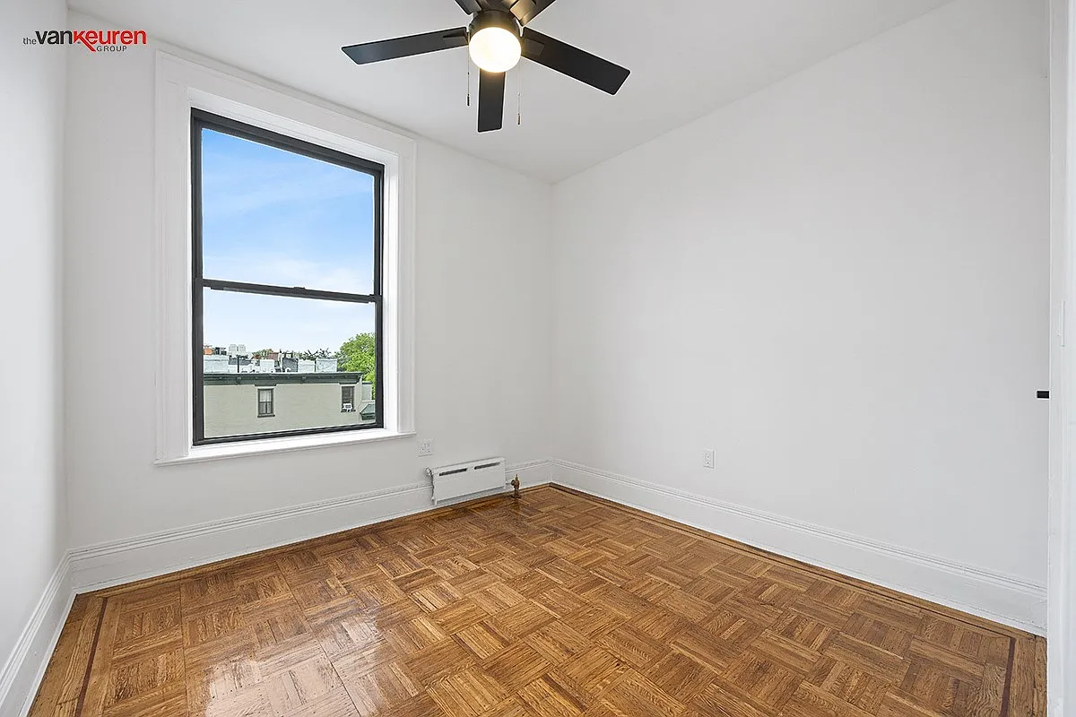a bedroom with a wood floor and a ceiling fan