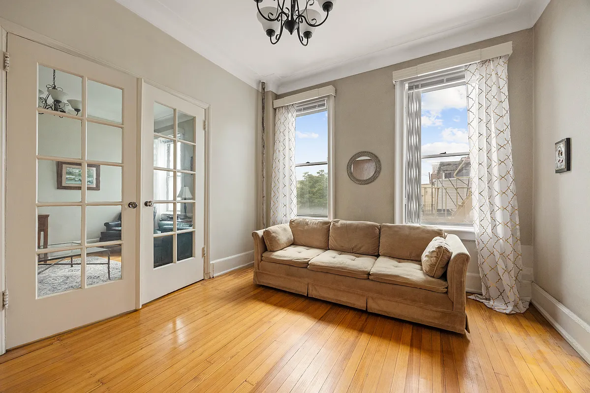 dining room or bedroom space with french doors, two windows, wood floor