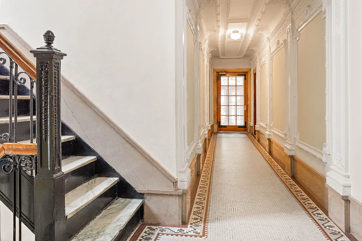 building hallway with tile floor, wall moldings, stair