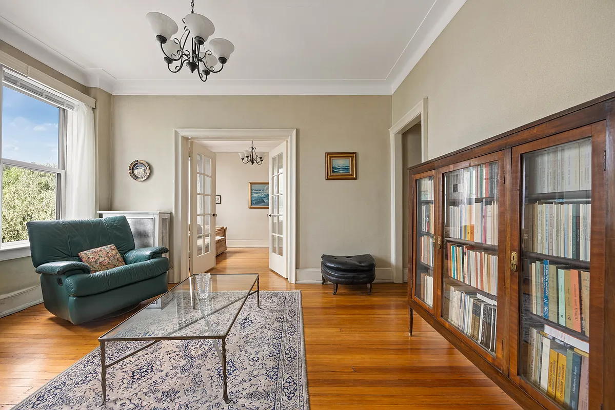 living room with wood floor, beige walls, cove molding, french doors leading to a dining room or second bedroom