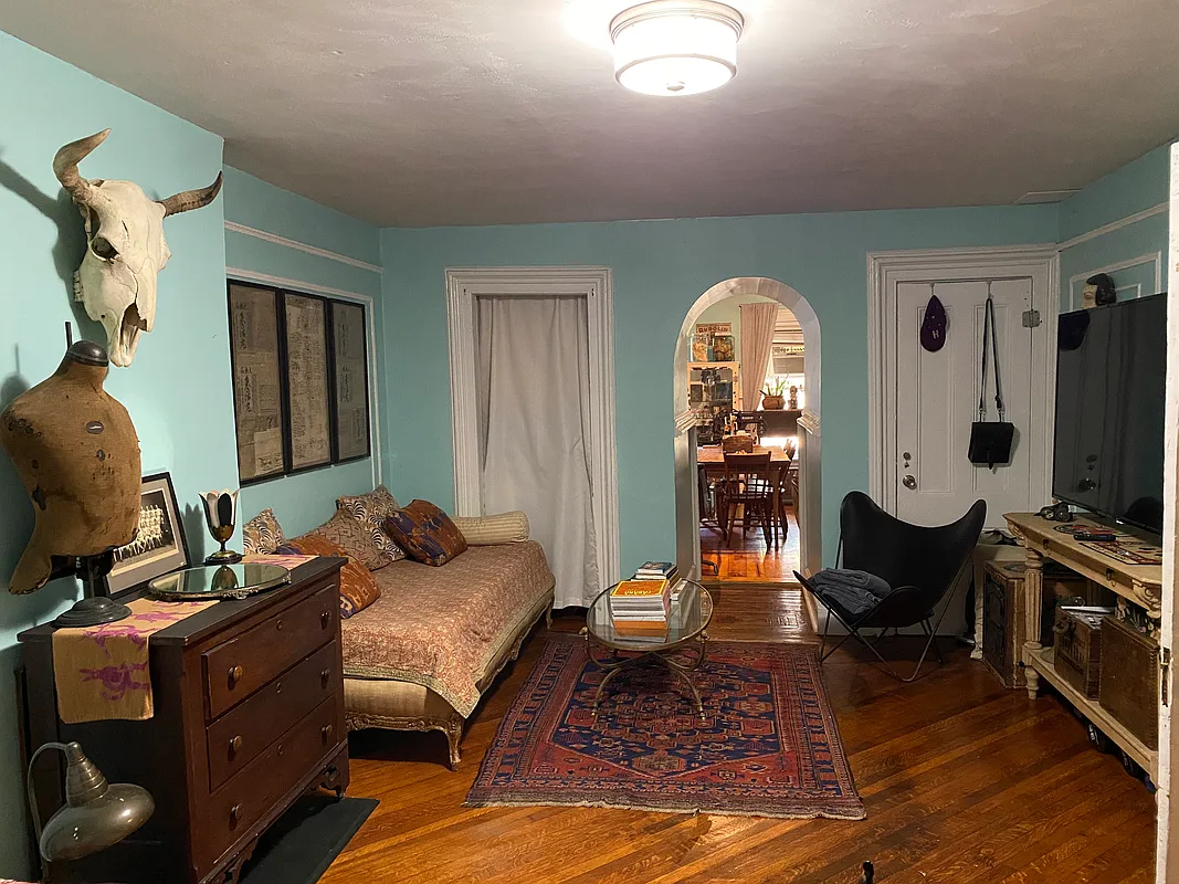 garden level with living room and sleeping space with arched doorway into the kitchen