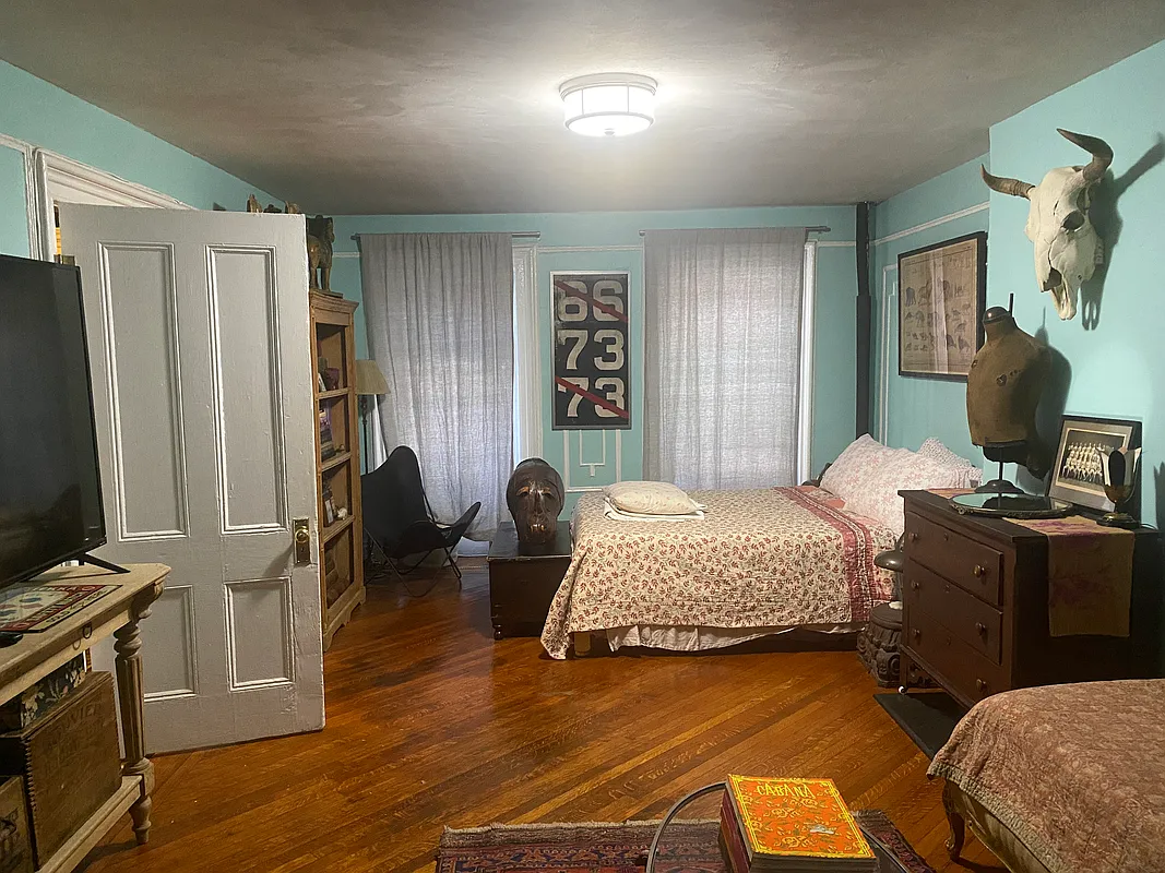 bedroom with wood floor, blue walls with wall moldings