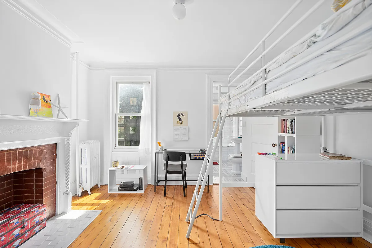 bedroom with white walls, white mantel and an ensuite bathroom