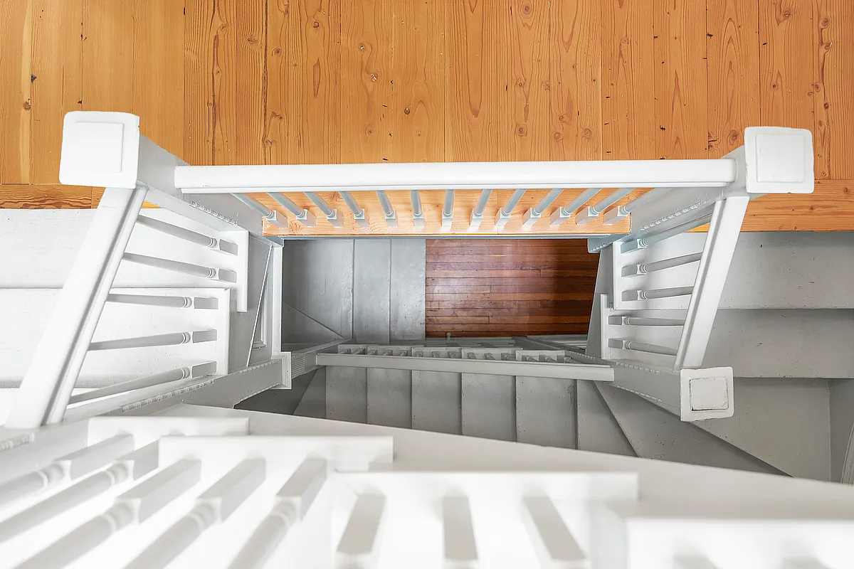 looking down at the staircase with white steps and white handrail
