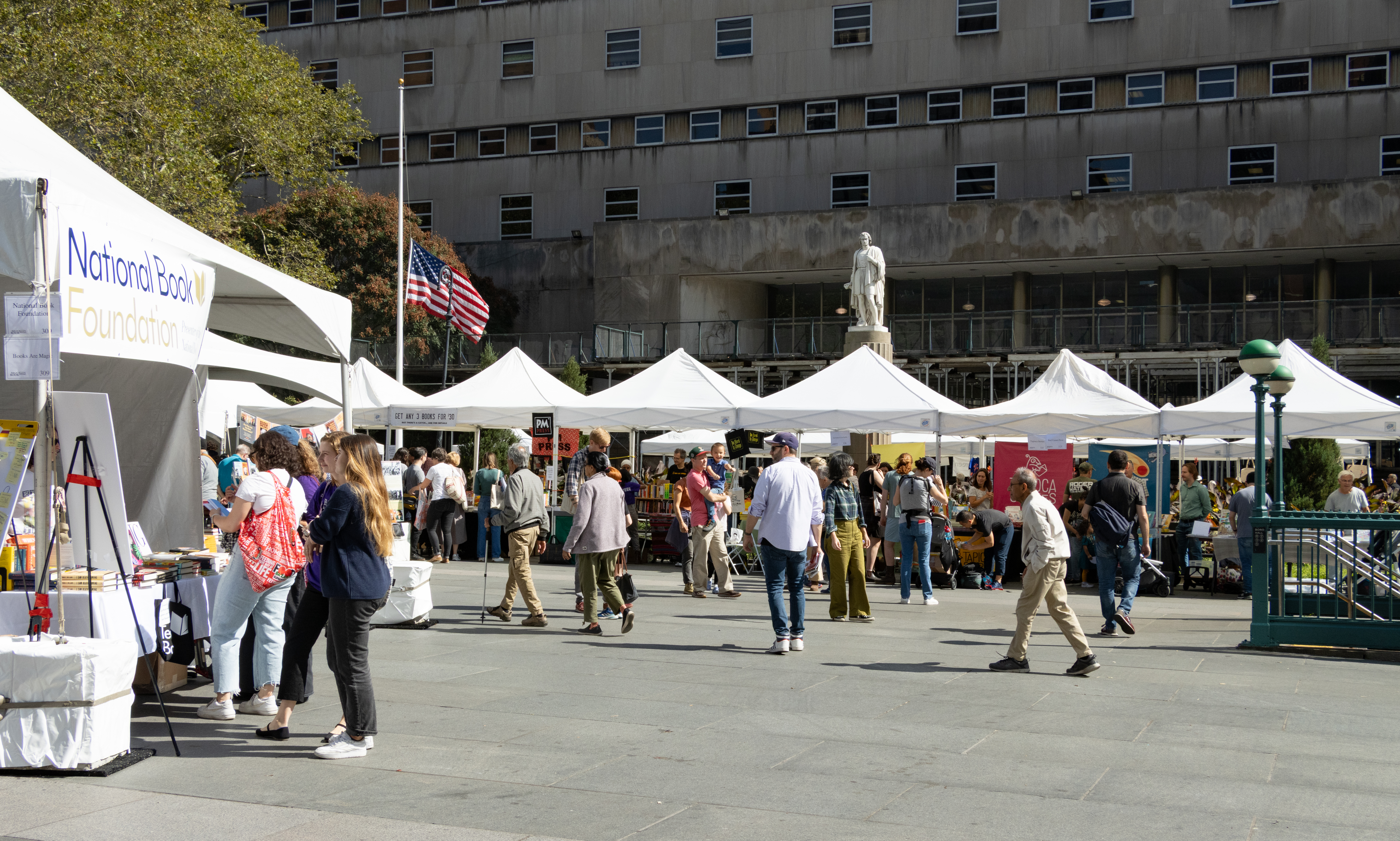 people browsing at tables under tents
