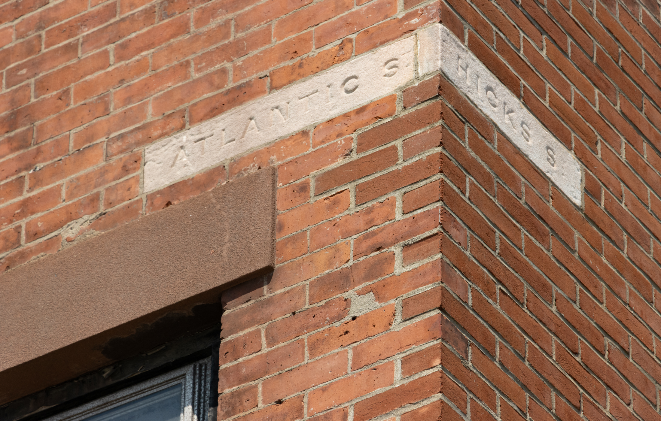 brick building with a limestone block wrapping a corner with atlantic st on one side and hicks st on the other