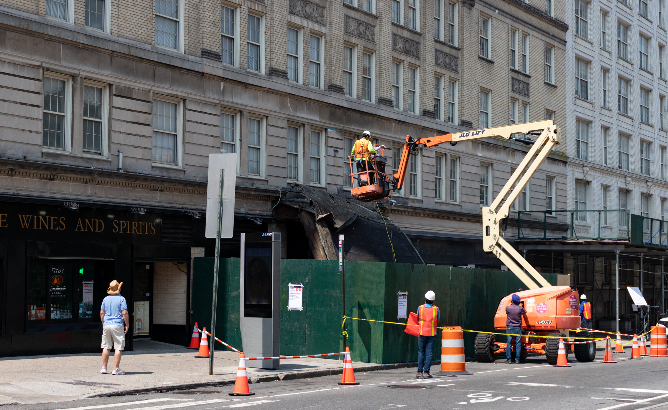workers in a cherry picker next to the collapsed marquee