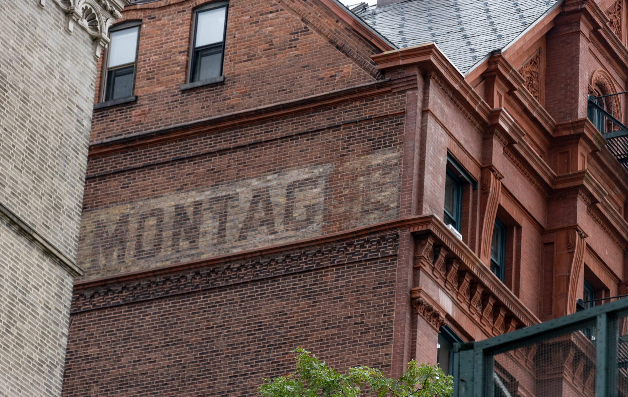 a ghost sign on the side of a brick building with "montague" spelled out