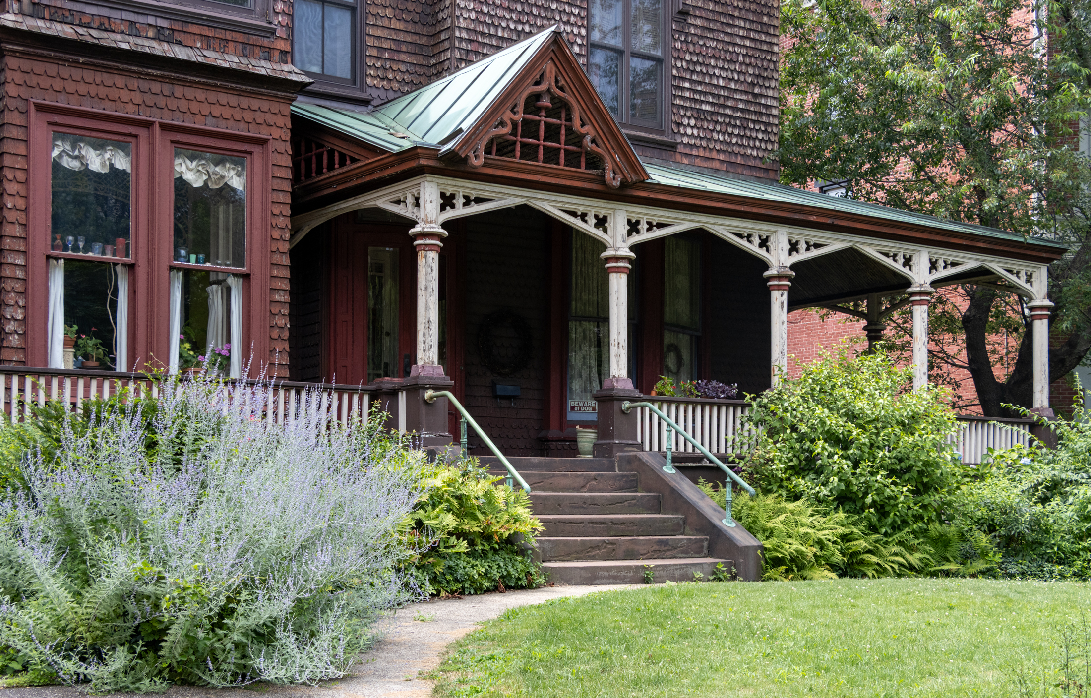 a front yard with a wood porch landscaping