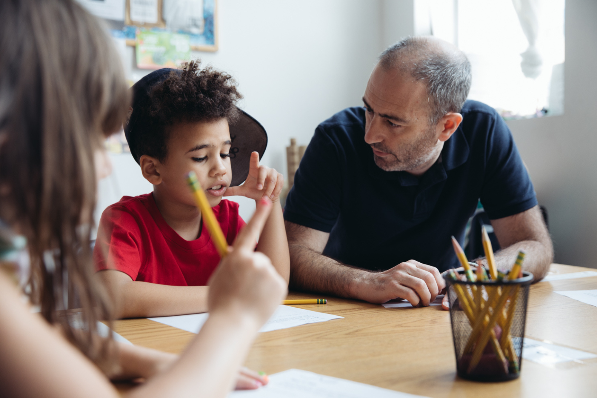 male teacher sitting next to student
