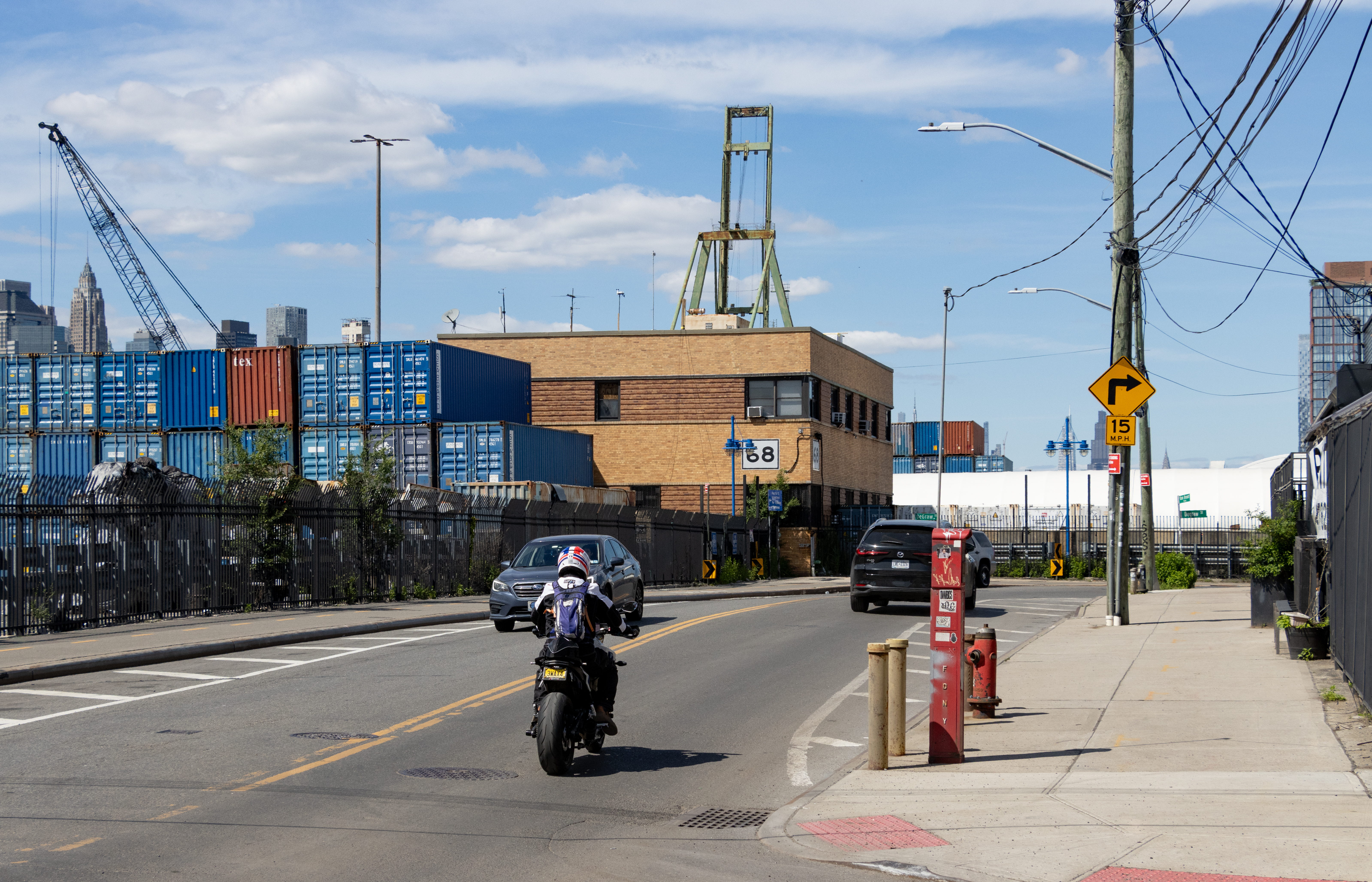 traffic going past containers stacked at the waterfront