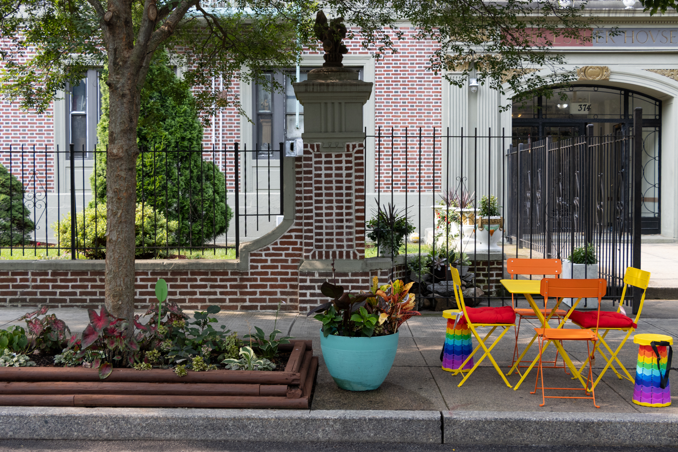 tables and chairs next to a tree pit