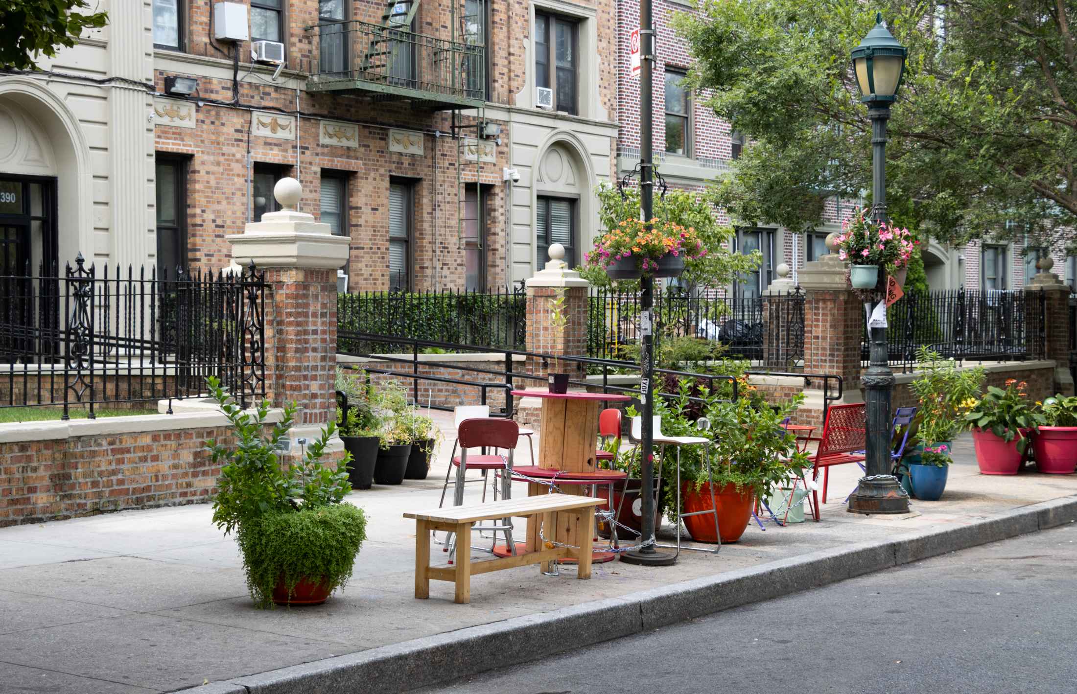 benches and seating on the sidewalk with planters filled with flowers