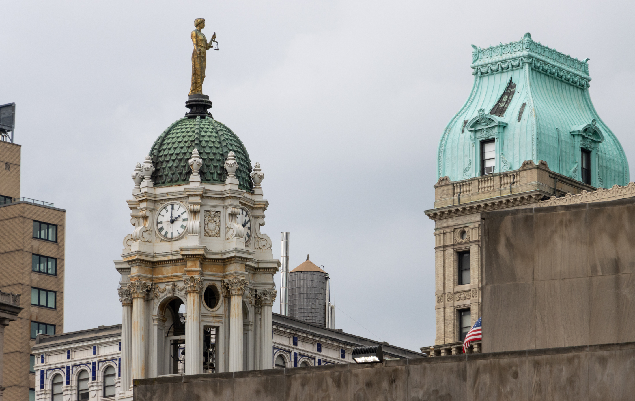 skyline of downtown brooklyn with the sculpture on the green roof of borough hall