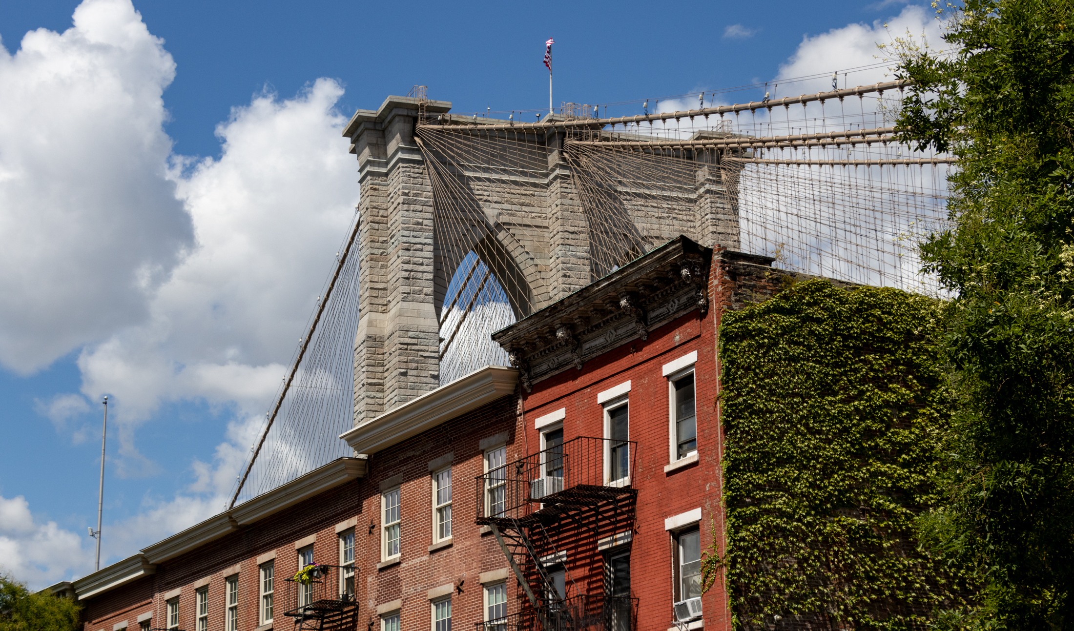 brooklyn bridge behind a row of brick houses