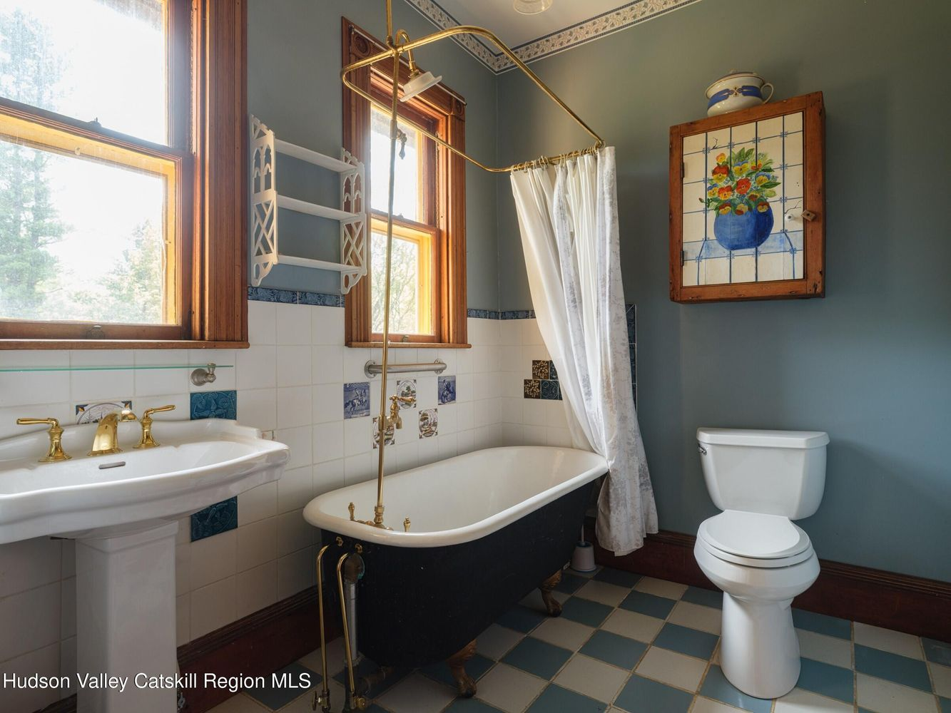 bathroom with blue and white checked tile floor, claw foot tub, blue walls