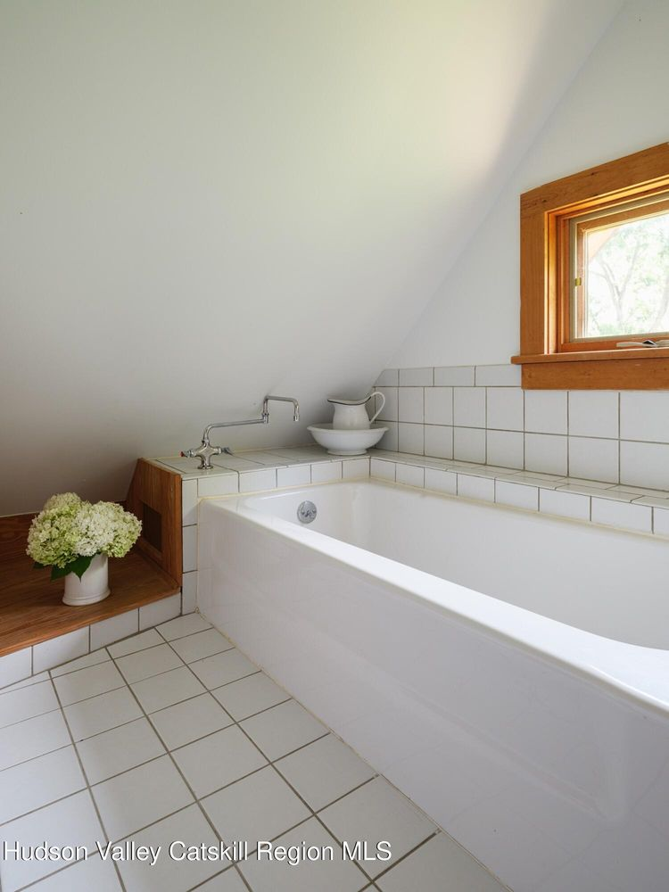 bathroom with white tile on floor and around a white tub