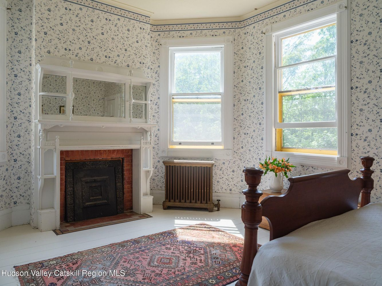 bedroom with white painted wood floor and trim, floral wallpaper