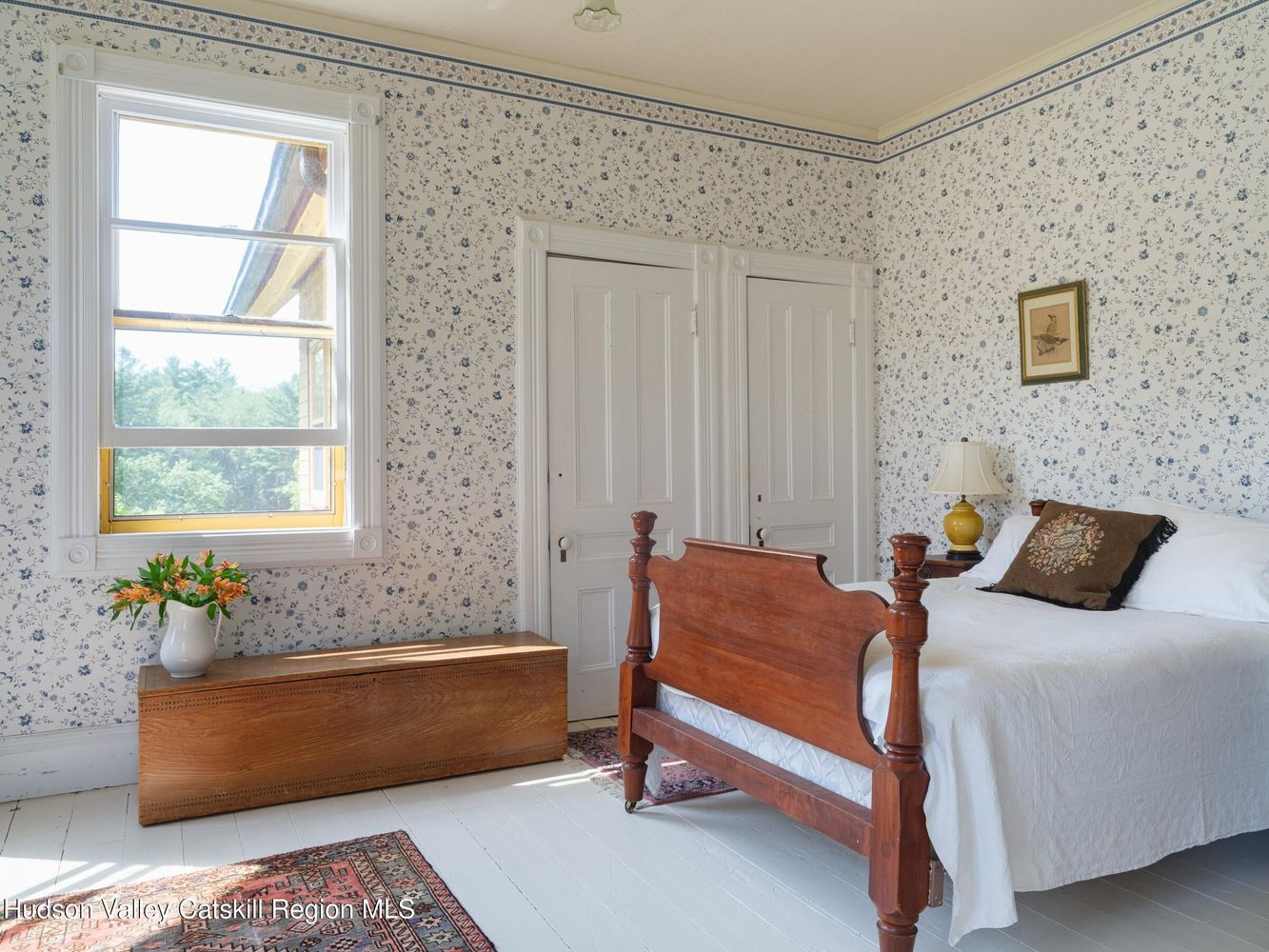bedroom with white painted wood floor and trim, floral wallpaper