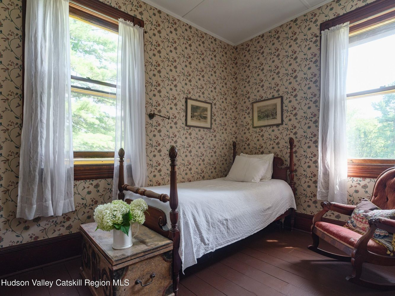 bedroom with floral wallpaper and two exposures