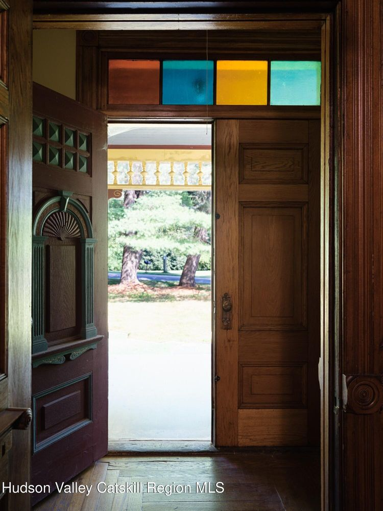 wood front door with a stained glass transom