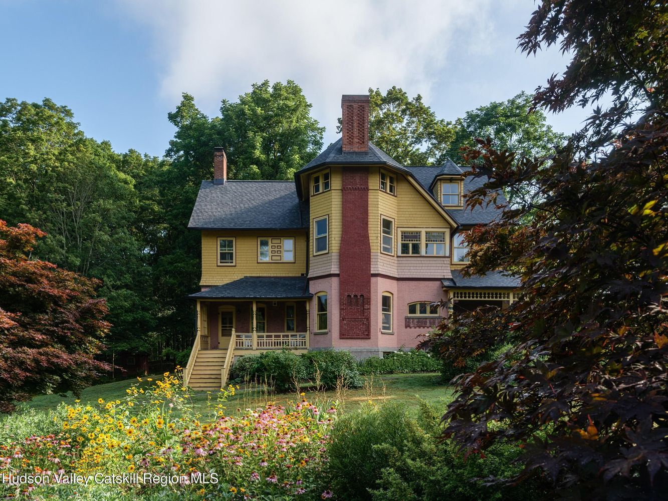 side facade with brick chimney and a small rear porch