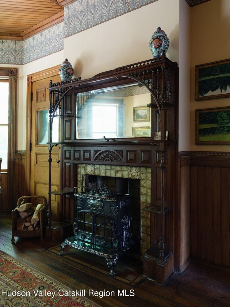 parlor mantel with fretwork, mirror, and a tile surround