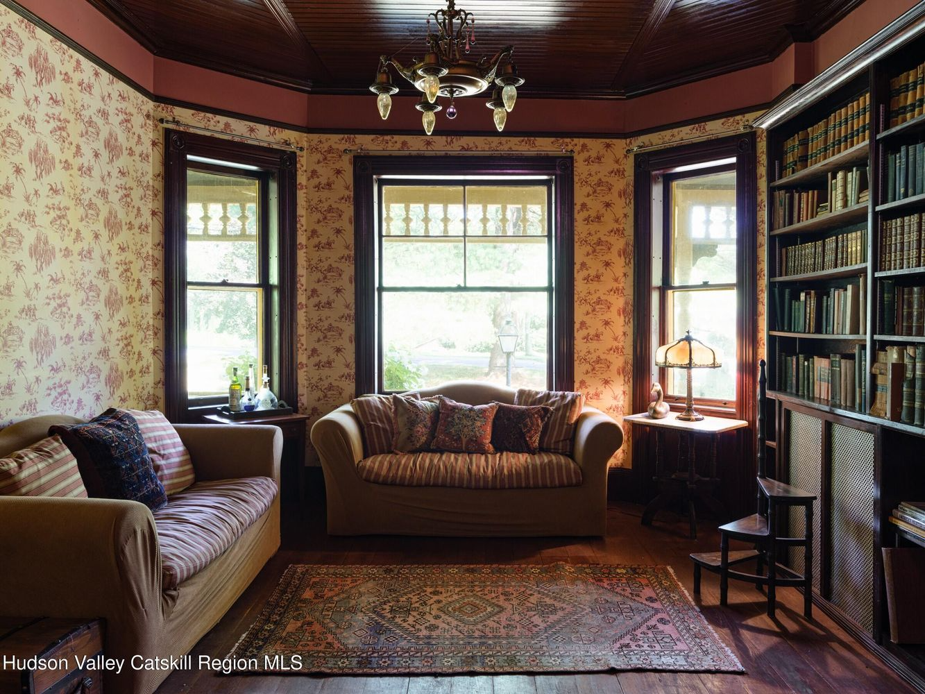 library with toile wallpaper, wood floor