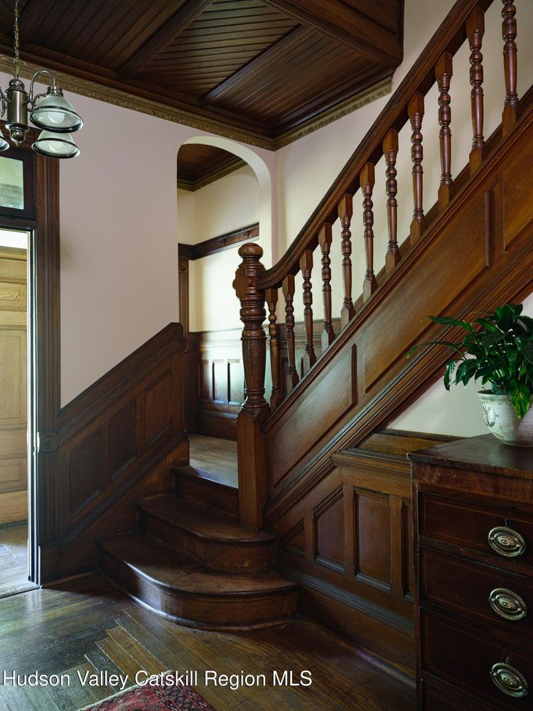 entry hall with stair, wainscoting, wood slats on ceiling