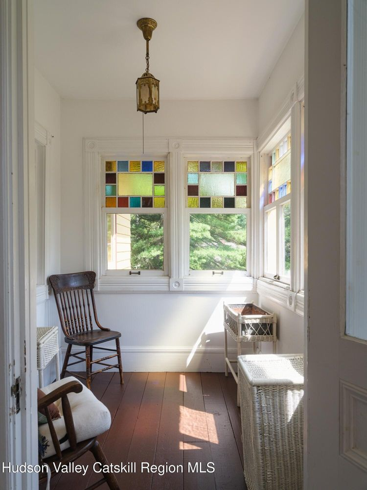 sun porch with stained glass in upper sash of windows