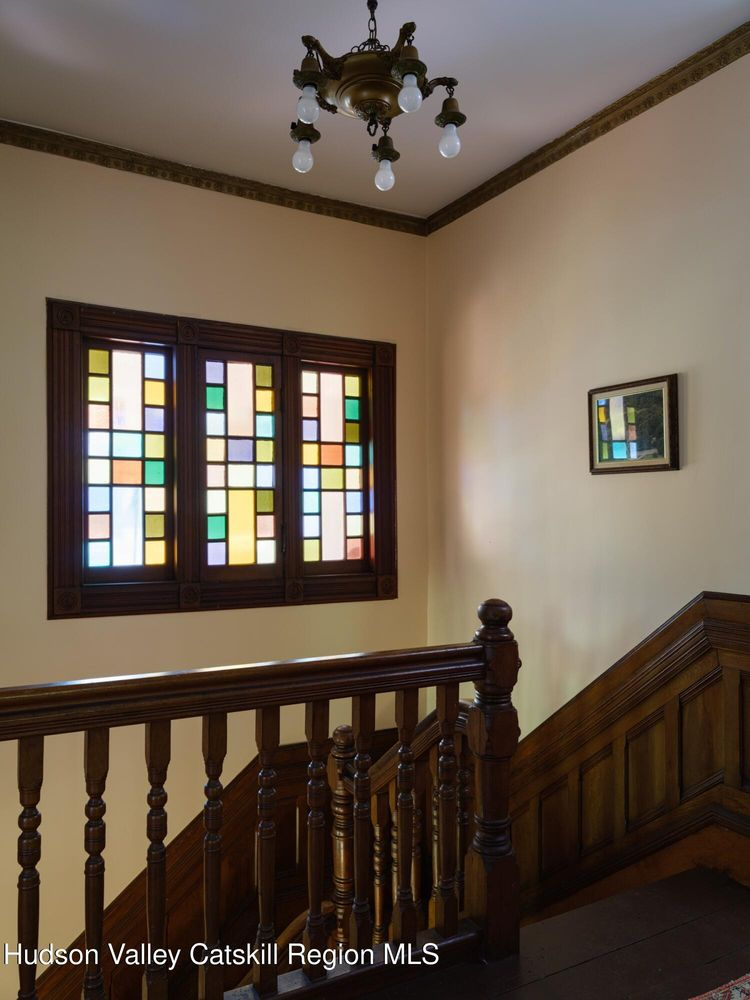 upstairs stair landing with window with sold color panes of stained glass