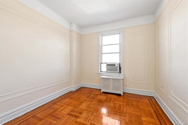 bedroom with wood floor, wall moldings