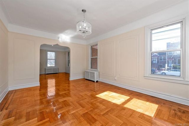 dining room with wood floor, arched doorway to living room