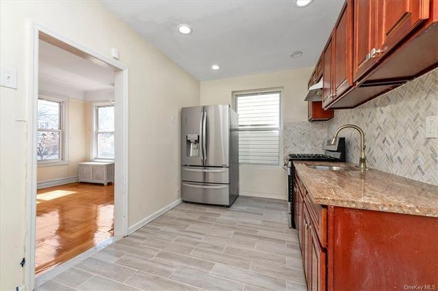 kitchen with tile floor, wood cabinets, view into dining room