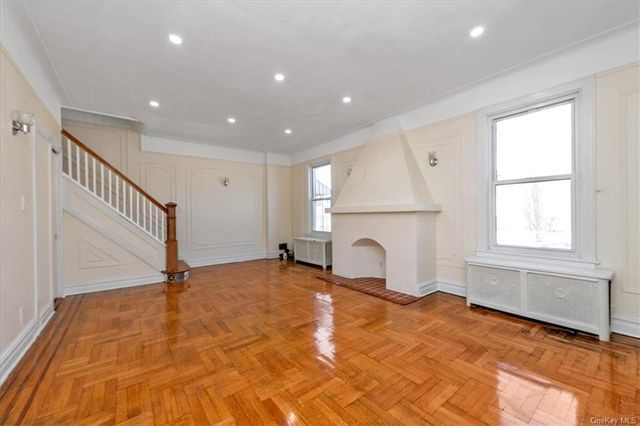living room with fireplace with wood floor, wall moldings