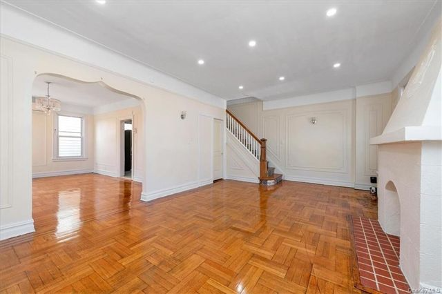 living room with wood floor arch to dining room