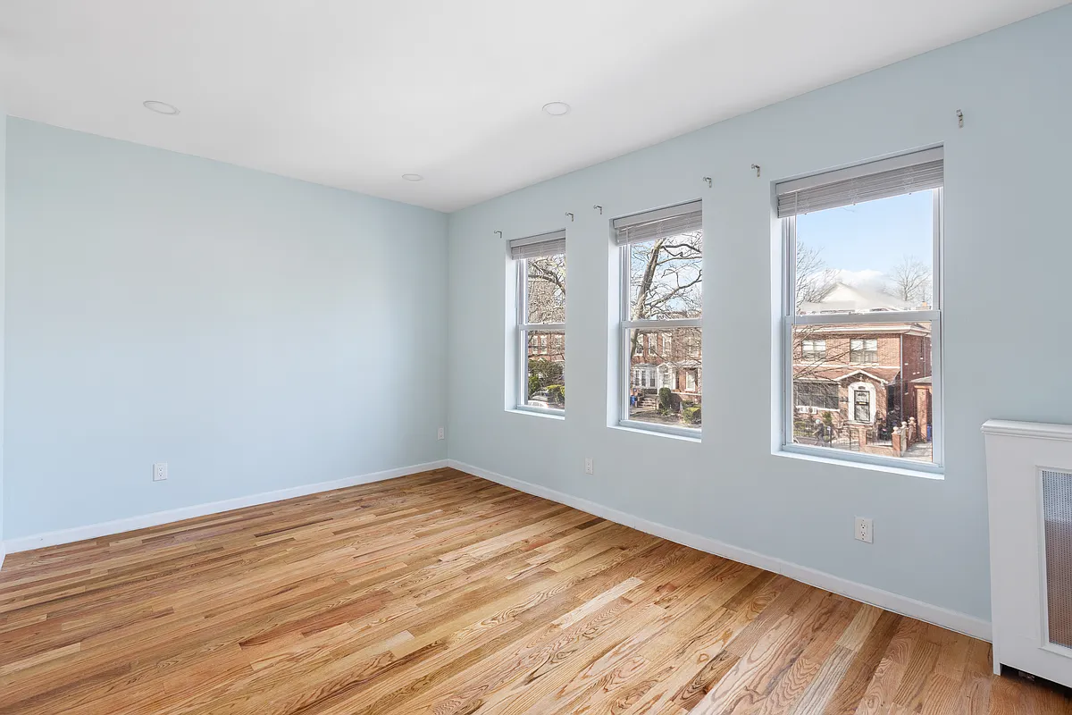 bedroom with three windows, blue walls, wood floor