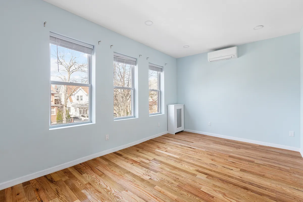 bedroom with three windows, wood floor