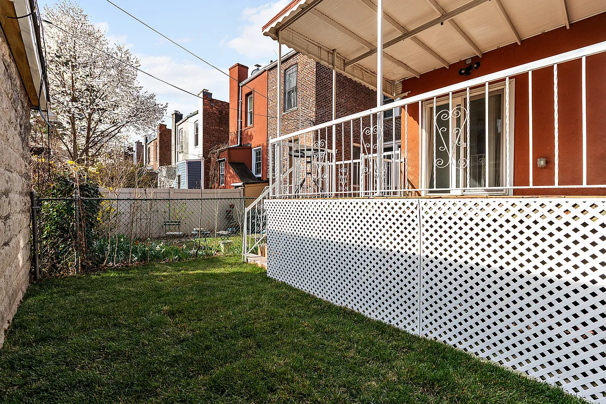 rear of the house with a deck and a small bit of yard