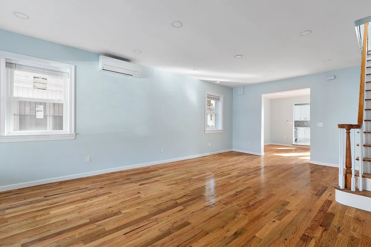 living room with blue walls, wood floor and a mini split unit mounted on the wall