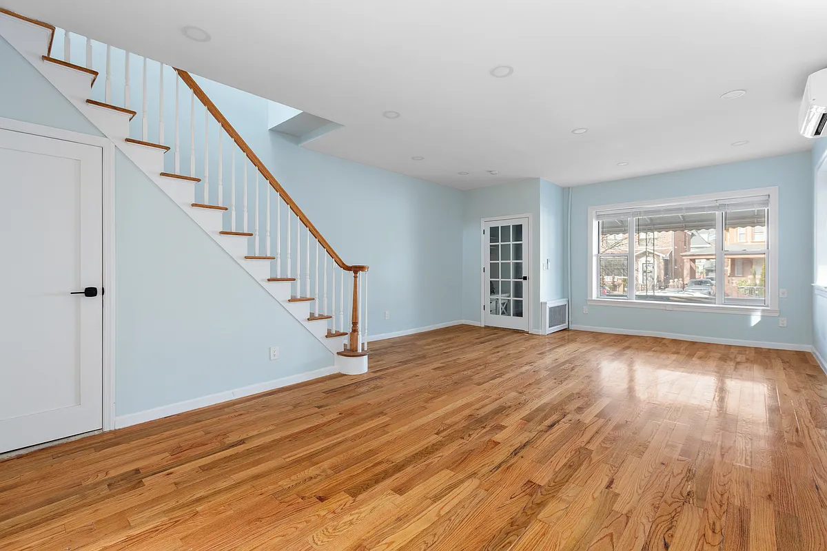 living room with blue walls, wood floor and a mini split unit mounted on the wall