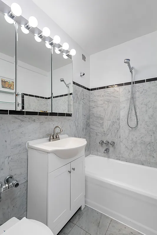 bathroom with marble wall tiles and white fixtures