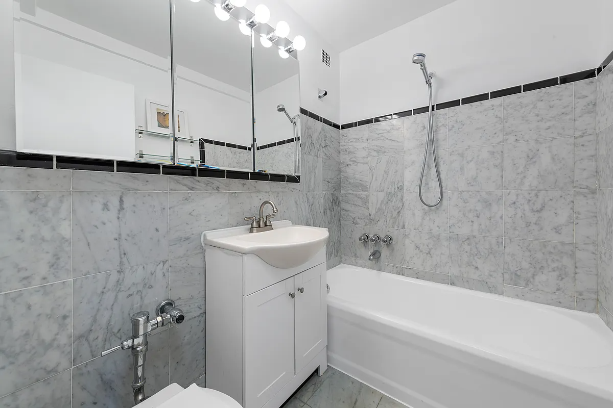bathroom with marble wall tiles and white fixtures