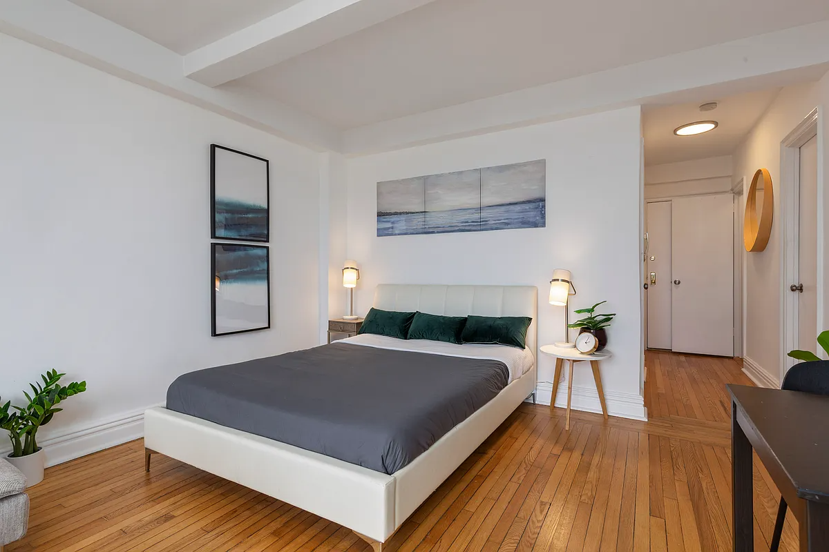 living space with wood floor and room for a bed