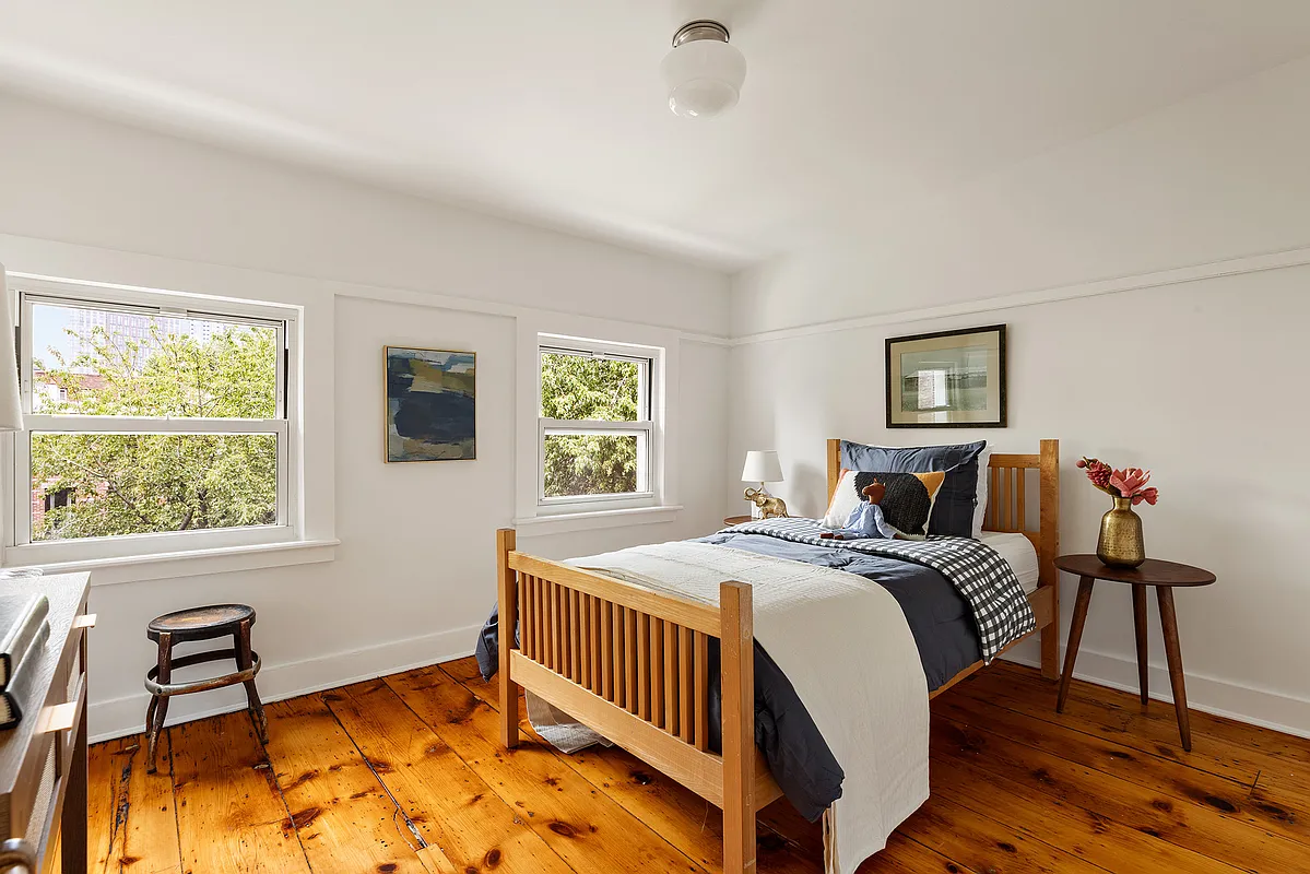 a top floor bedroom with wide planked floorboards, white walls