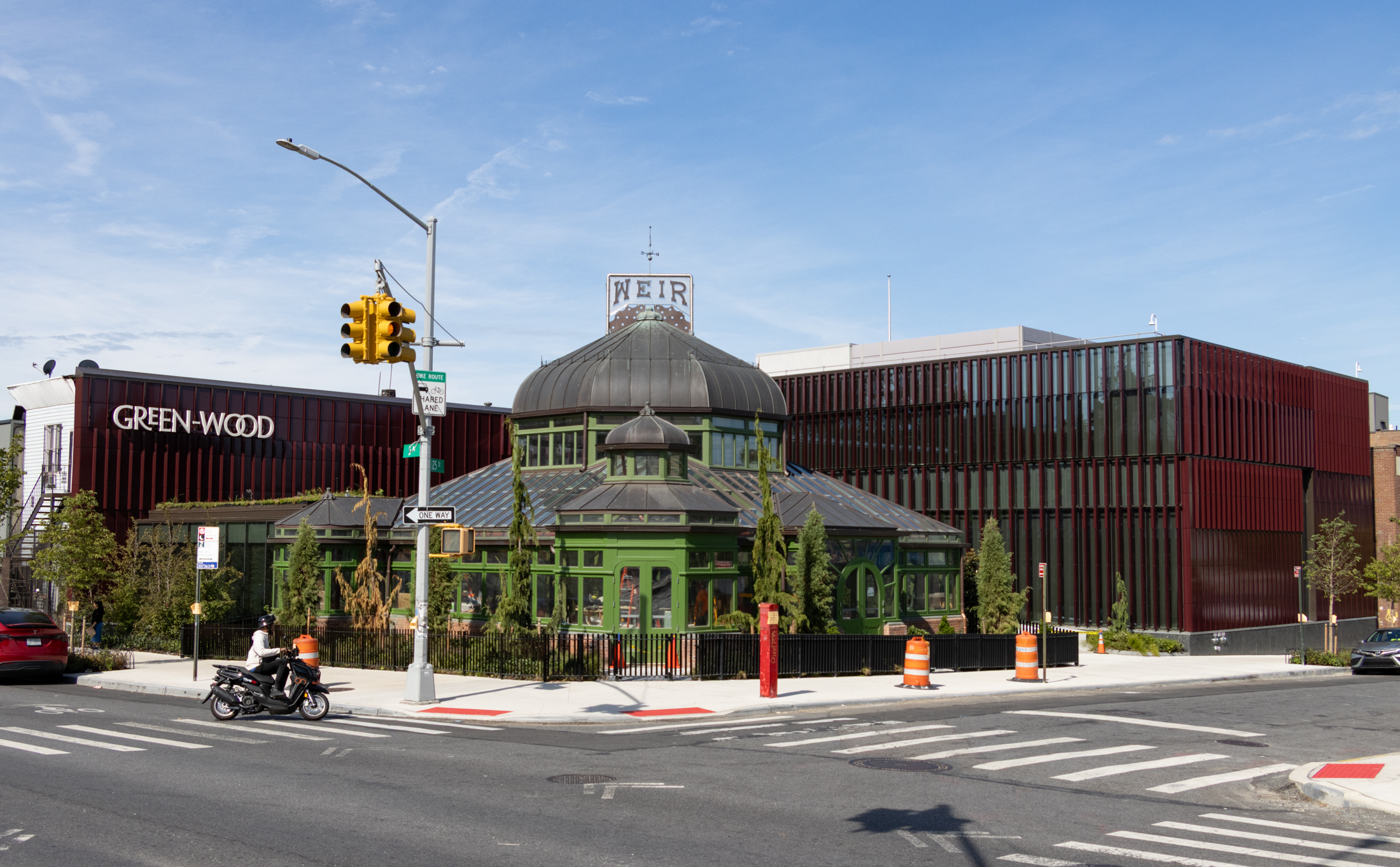 the completed visitors center with the restored weir greenhouse at the center and new construction with terra cotta panels on either side