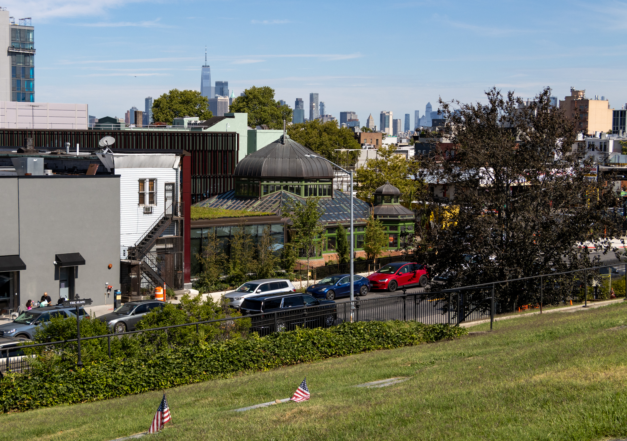 view inside the cemetery with the visitors center visible and the manhattan skyline in the distance