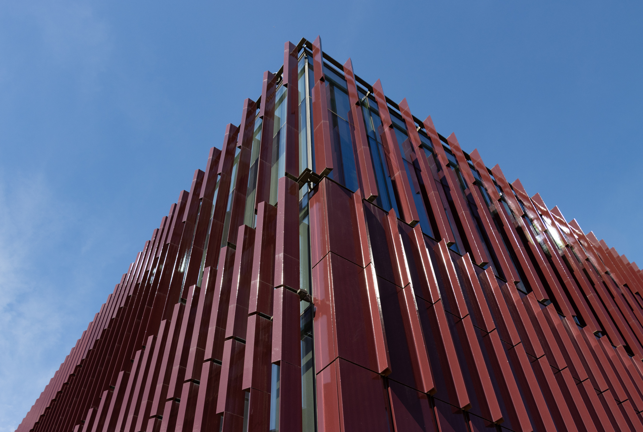 a corner of the new building showing solid panels and slat panels with windows